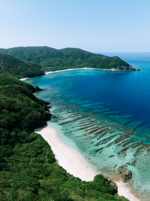 Aerial view of deserted tropical beach, coral reef and lush green mountains, Kakeroma Island, Amami Islands, Japan